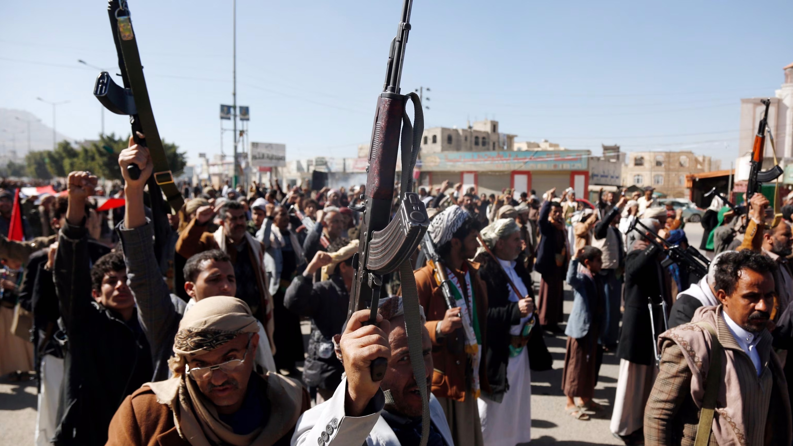 Yemeni protestors loyal to the Houthi movement lift their rifles as they participate in a protest held against Israel
